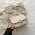 Elegante borsa beige a tracolla con chiusura dorata abbinata a un blazer color crema - Bianco