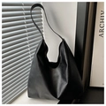 Detail of matte black PU leather tote bag with wide strap against a minimalist window - Black