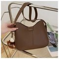 Detail of dark brown leather crescent bag with fashion logo and plush bear charm - Glasses Pom-Pom Pendant / Brown