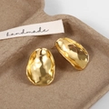 Macro shot of gold-plated brass earrings with a textured concave lava surface - Large / Earring Post / Gold