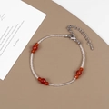 Dettaglio di perle di pietra rossa su una collana di vetro trasparente e chiusura argento - Braccialetto di Perline in Pietra Naturale Rossa