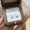 Close-up of sparkling four-prong AAA zircon earrings in a premium wooden jewelry box - Silver