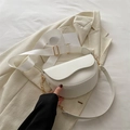 White saddle shoulder bag with wide nylon strap and gold hardware on cream blazer - White