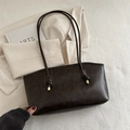 Dark brown matte leather tote bag with gold hardware accents on light textured fabric - Coffee No Charm