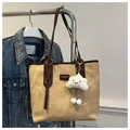 Detalle del bolso tote de lona beige con asas de cuero marrón y colgante de nube - Con Colgante de Nube / Caqui