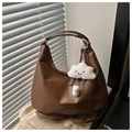 Detail of hobo bag in dark brown faux leather with cloud plush charm on window sill - With Pendant / Brown
