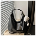 Close-up of black PU leather hobo bag with plush dog charm on beige fleece surface - With Pendant / Black