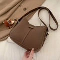 Dark brown leather saddle crossbody bag with a plush bear charm and golden buckle - With Pendant / Brown