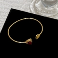 Dettaglio macro del bracciale aperto placcato oro 18K con zircone cuore rosso e micro-pave - Bracciale in Zirconia Rossa