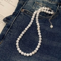 Detail einer weißen Perlenkette mit Silberverschluss auf dunkelblauem Denim-Hintergrund - 5mm Muschelhalskette