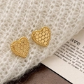 Pendientes de corazón bañados en oro con textura de panal sobre suéter blanco - Dorado