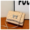 Detail of beige quilted bag with silver bow ornament and chain shoulder strap - Khaki