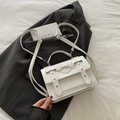 White PU crossbody bag with heart stitching and bow detail on a grey background - White