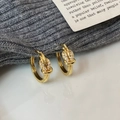 Detailaufnahme vergoldeter Knoten-Ohrringe mit fein gefassten weißen Zirkonia - Gold