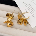 Macro shot of 18K gold layered flower petal earrings in a luxury jewelry box - Gold