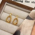 Polished golden irregular oval hoop earrings presented in a wooden jewelry box - Gold Linked Hoop Earrings