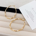 Detailopname van gouden gedraaide creolen op een luxe fluwelen sieradendisplay - Gouden Grote Creolen (Echt Goud Verguld)