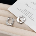 Dettaglio degli orecchini a cerchio irregolari in argento su un vassoio di velluto - Orecchini a forma di U argento