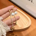 Elegantes pendientes dorados con flecos, perlas y cristales en una vista de estilo de vida - Estilo de Borla de Perla Dorada de Doble Bola (Dos Formas de Uso)