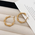Elegantes pendientes de aro dorados y trenzados con textura mate en joyero color crema - Dorado Mate