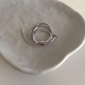 Macro shot of silver snake chain ring with adjustable slide bead on ceramic tray - Silver
