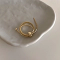 Macro shot of 18K gold snake chain wrap ring with polished square metal buckle and beads - Gold