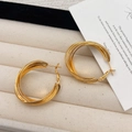 Elegante gouden gelaagde creolen gepresenteerd op een beige fluwelen juwelendoosje - Gouden meerlaagse verweven stijl (A-548) / Goud