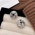 Macro shot of silver knotted spiral earrings displayed inside a velvet jewelry box - Spherical Spiral Rope Knot Style (A-1088)