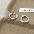 Macro view of geometric square hoop earrings in silver metal on a handmade paper tray - Silver