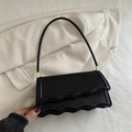 Minimalist black baguette shoulder bag featuring scalloped flap and gold-tone hardware - Black
