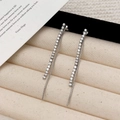 Detailed view of silver tassel earrings with zircon studs on beige velvet jewelry tray - Silver Zirconia Tassel Stud Earrings