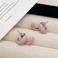 Schicke rosa Emaille-Ohrringe in C-Form mit minimalistischem Design auf Schmucktablett - Rosa