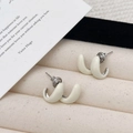 Elegante C-förmige Emaille-Ohrstecker in Cremeweiß mit silberfarbenen Metallakzenten - Gebrochenes Weiß