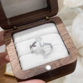 Detalle de anillo de camelia ajustable con flor blanca y circón en caja de madera lujo - Plateado