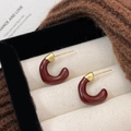 Deep red C-shaped hoop earrings with gold plating and enamel finish in a jewelry box - Ancora Red Enamel C-shaped Earrings