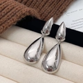 Polished silver tiered teardrop earrings displayed on a minimalist textured surface - Silver Waterdrop Earrings / Silver