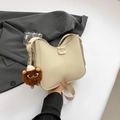 Chic beige half-moon shoulder bag in faux leather with playful monster charm accessory - Beige With Charm