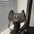 Retro denim dumpling bag with silver bow and pearl chain strap, lifestyle setting - Black