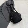 Sac bandoulière polyvalent en nylon plissé noir posé sur une veste de costume grise - Sans Pendentif / Noir