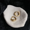 Detail of minimalist chunky gold hoop earrings on a white textured display tray - Matte Gold Style (2313)
