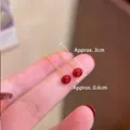 Detalle de pendientes con perlas rojas con longitud 3cm y diámetro de perla de 0,6cm - Hilo de Oreja de Perla Roja con Borla Dorada