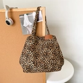 Makroansicht der Canvas-Tasche mit Leopardenmuster und hochwertigem Leder-Logo-Patch - Braun