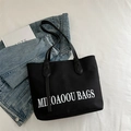 Black canvas tote bag with white MI KAOOU BAGS embroidery for casual commuting - Black