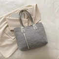 Hellgraue Shopper-Tasche aus Lammwolle mit Ledergriffen in legerer Lifestyle-Einstellung - Grau