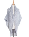 Dettaglio di un poncho in maglia a righe grigie e bianche con lunghe frange sui bordi - Taglia unica / Grigio