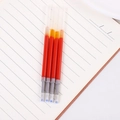 Close-up of four red 0.5mm gel ink refills with blue protective tips on a notebook - Red