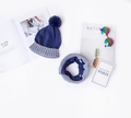 Flat lay of knit hat and scarf set with pom-pom detail on a minimalist white background - Hat and Neck Warmer Navy Set