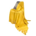 Bright yellow knitted throw blanket with diamond pattern and long tassels on grey chair - Yellow
