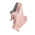 Pink knit blanket with diamond texture and tassels draped over a chair - Pink