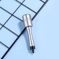 Macro detail of silver grenade-shaped pen with engraved 612 markings and metal loop - Gray